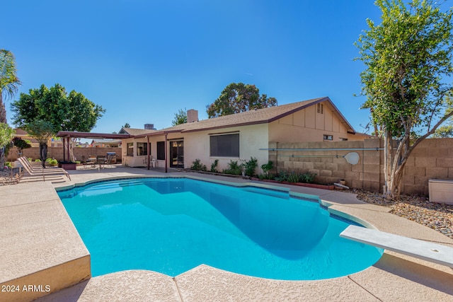 view of pool featuring a diving board and a patio