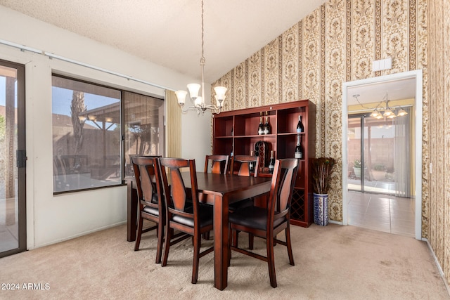 dining room featuring carpet floors, a textured ceiling, and a chandelier