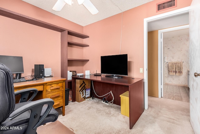 carpeted office with ceiling fan and a textured ceiling