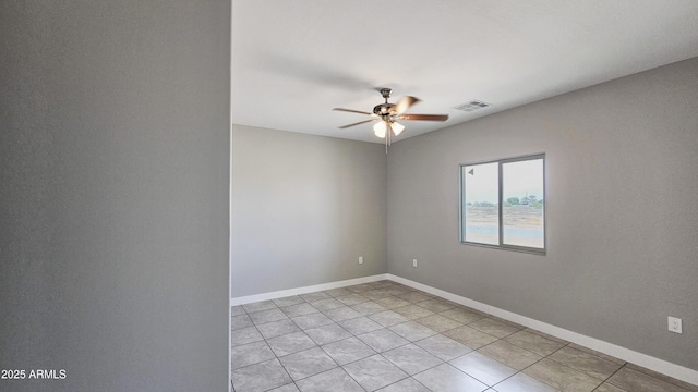 unfurnished room with ceiling fan, light tile patterned flooring, and baseboards