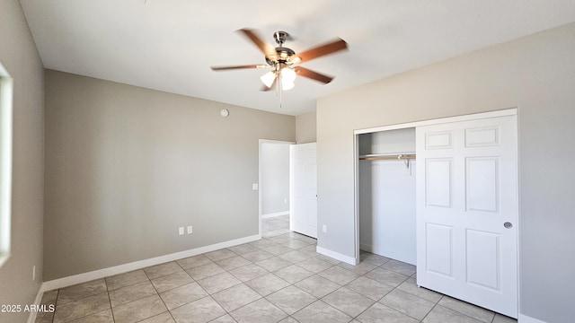 unfurnished bedroom with a closet, light tile patterned floors, baseboards, and ceiling fan