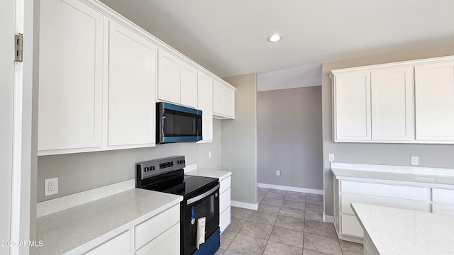 kitchen with electric range, light countertops, white cabinets, baseboards, and recessed lighting