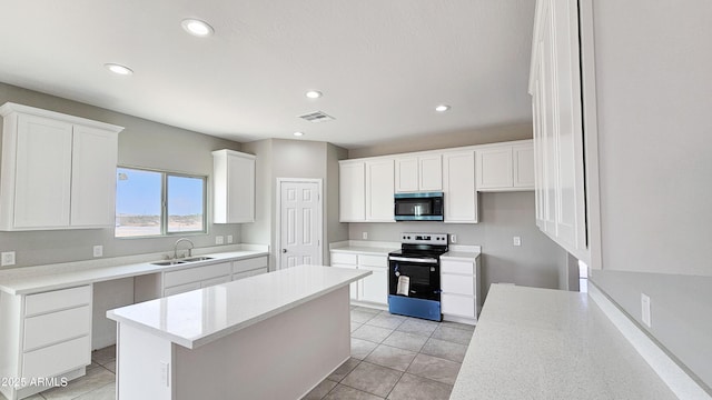 kitchen with stainless steel microwave, electric range oven, a sink, a center island, and white cabinets
