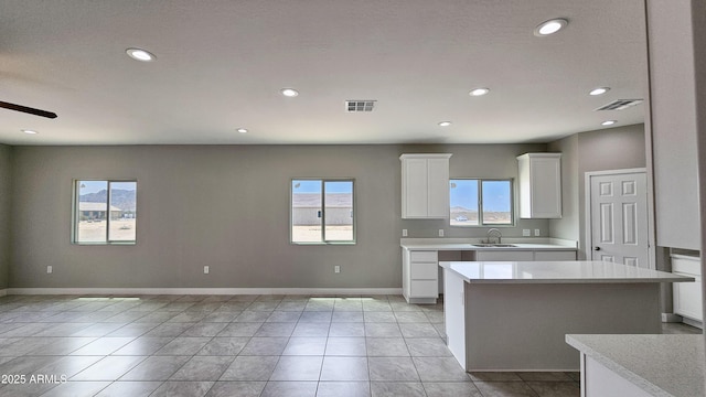 kitchen featuring a sink, plenty of natural light, light countertops, recessed lighting, and white cabinetry