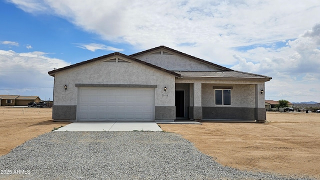 view of front of property featuring stucco siding, driveway, and an attached garage