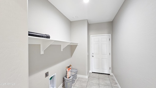 laundry area with electric dryer hookup, light tile patterned floors, and baseboards