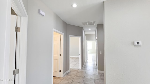 hallway featuring light tile patterned flooring, recessed lighting, and baseboards