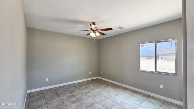 unfurnished room featuring ceiling fan, baseboards, and light tile patterned floors