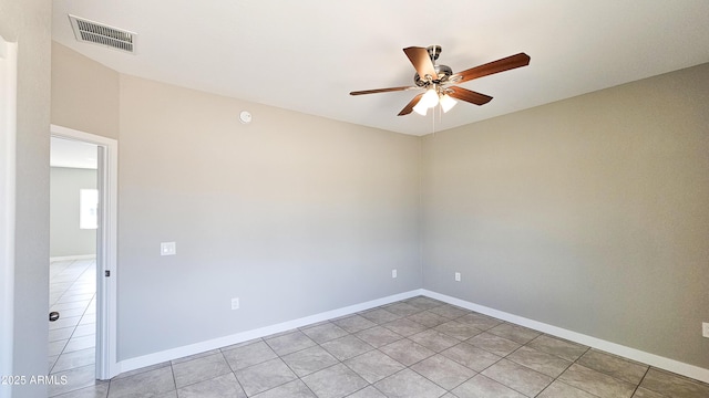 empty room featuring a ceiling fan, light tile patterned floors, and baseboards