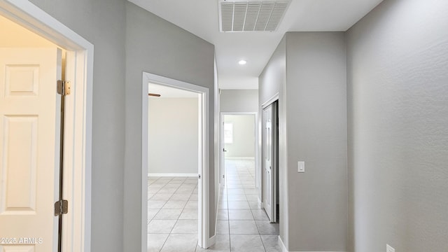 corridor featuring light tile patterned floors, recessed lighting, and baseboards