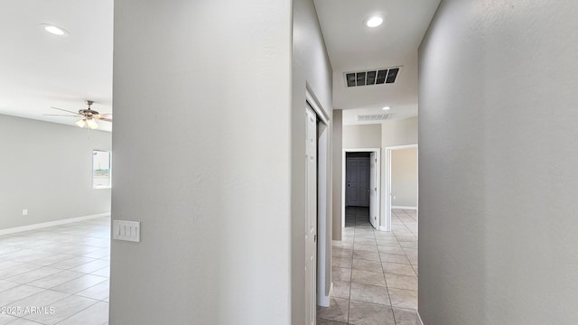 hallway with light tile patterned floors, recessed lighting, and baseboards
