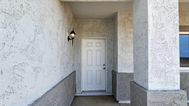 view of exterior entry with stucco siding