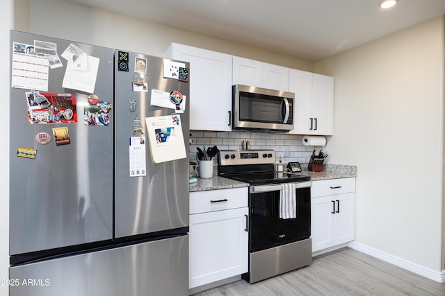 1635 W Cottonwood Bluffs Dr, Benson, AZ 85602 - kitchen with appliances with stainless steel finishes, light wood-style flooring, tasteful backsplash, white cabinets, and baseboards