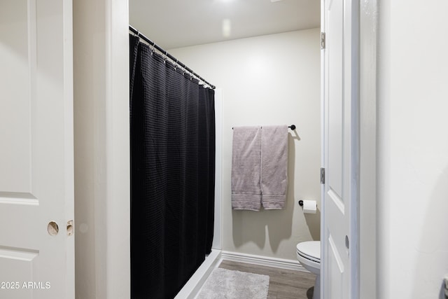 1635 W Cottonwood Bluffs Dr, Benson, AZ 85602 - bathroom with toilet, wood finished floors, curtained shower, and baseboards