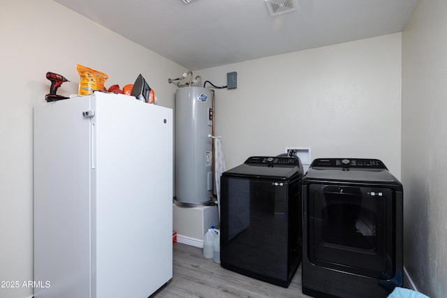 1635 W Cottonwood Bluffs Dr, Benson, AZ 85602 - washroom featuring water heater, washing machine and dryer, light wood-style flooring, and baseboards
