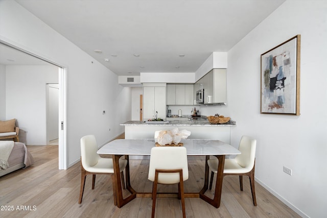 7180 E Kierland Blvd Unit 814, Scottsdale, AZ 85254 - dining room with light wood-style flooring and baseboards