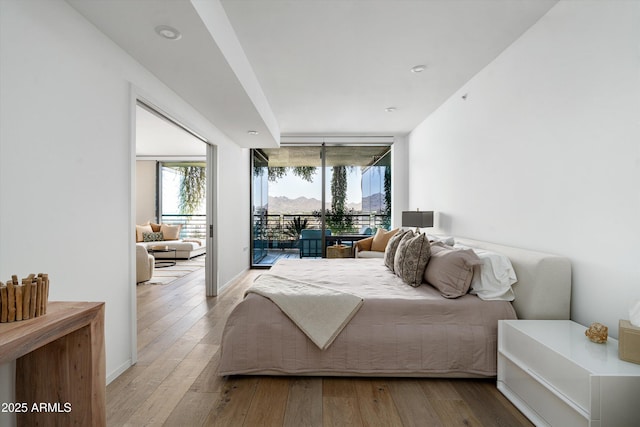 7180 E Kierland Blvd Unit 814, Scottsdale, AZ 85254 - bedroom with light wood-type flooring, multiple windows, access to exterior, and a wall of windows