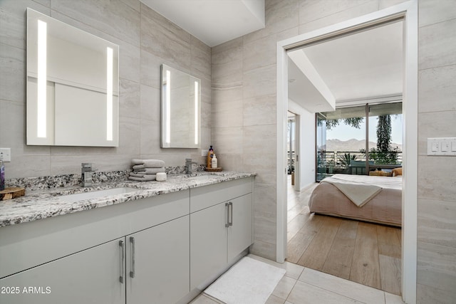 7180 E Kierland Blvd Unit 814, Scottsdale, AZ 85254 - full bathroom with double vanity, tile walls, ensuite bath, and tile patterned flooring