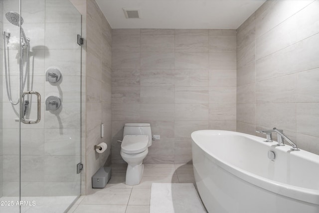 7180 E Kierland Blvd Unit 814, Scottsdale, AZ 85254 - bathroom with a freestanding bath, tile walls, a shower stall, tile patterned flooring, and toilet