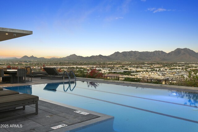 7180 E Kierland Blvd Unit 814, Scottsdale, AZ 85254 - pool at dusk featuring a mountain view, an outdoor pool, and a patio