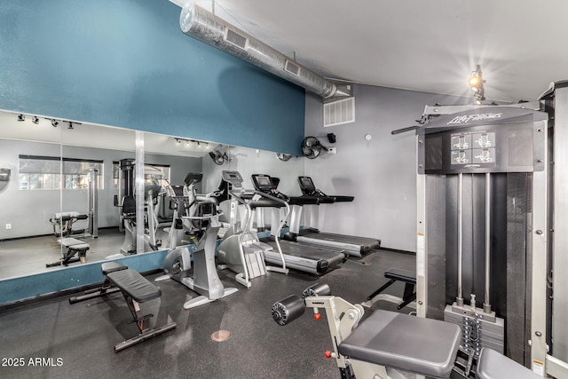 gym featuring visible vents, vaulted ceiling, and baseboards