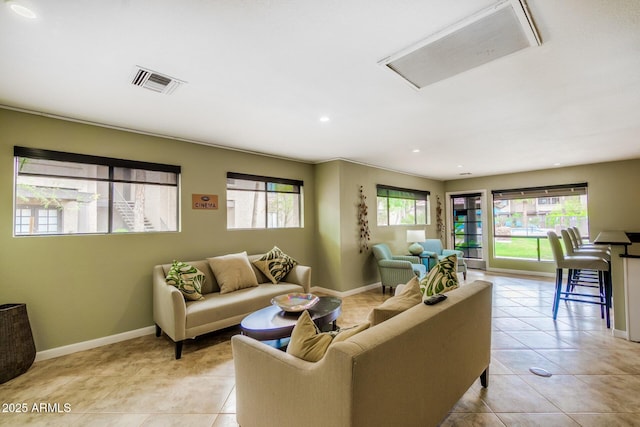 living area with light tile patterned floors, baseboards, visible vents, and recessed lighting