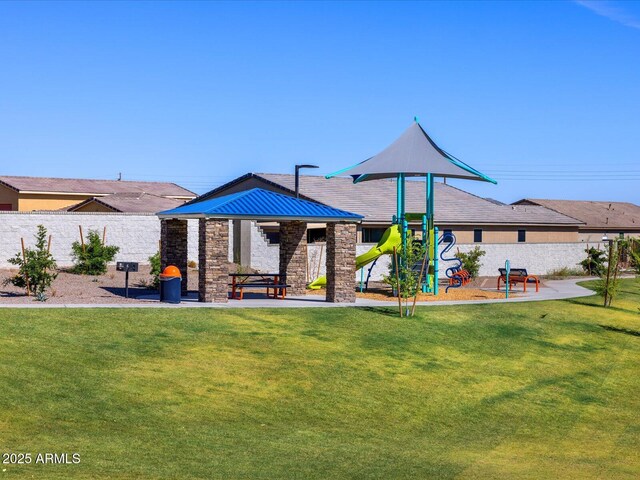 rear view of property featuring a playground, stone siding, metal roof, and a standing seam roof