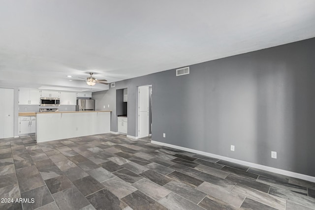 unfurnished living room with ceiling fan