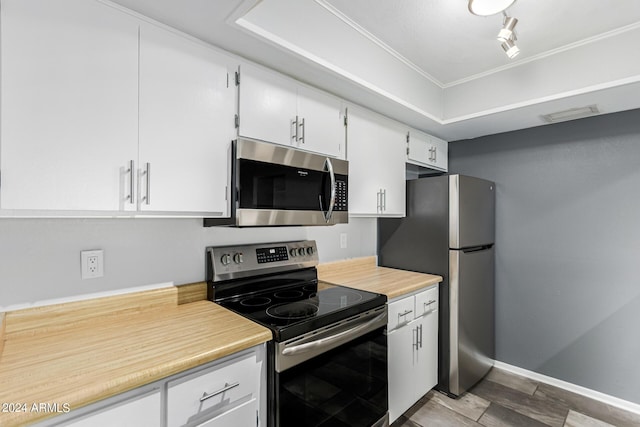 kitchen with white cabinets, appliances with stainless steel finishes, and rail lighting