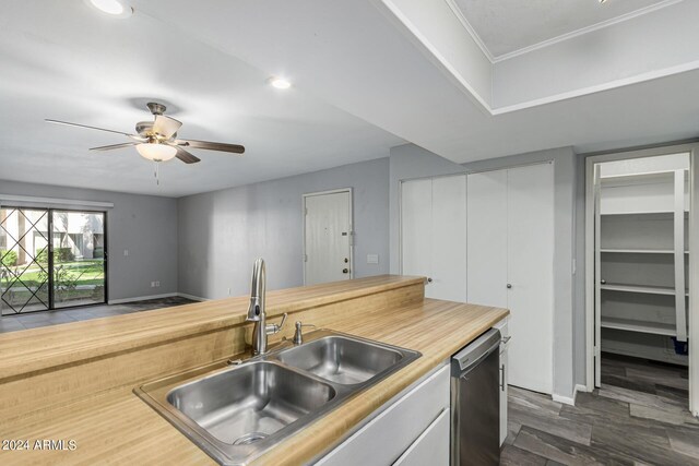 kitchen with ceiling fan, sink, dark hardwood / wood-style flooring, stainless steel dishwasher, and crown molding