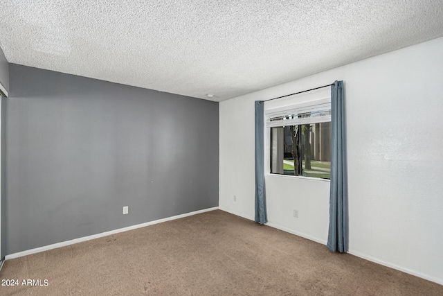 carpeted spare room featuring a textured ceiling