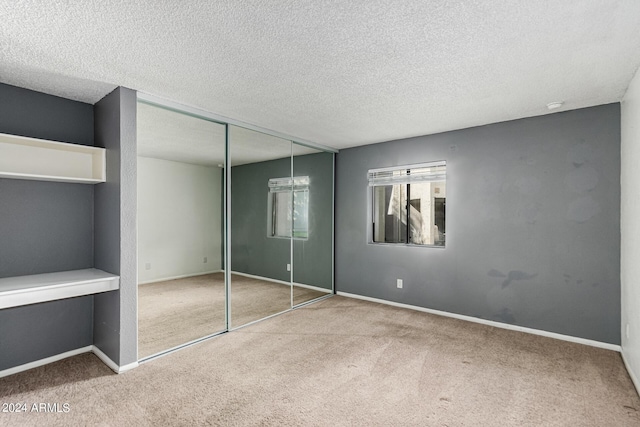 unfurnished bedroom featuring a closet, carpet, and a textured ceiling