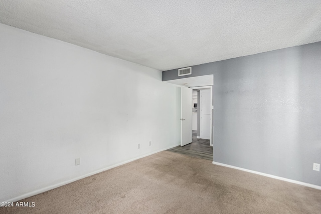 carpeted spare room with a textured ceiling