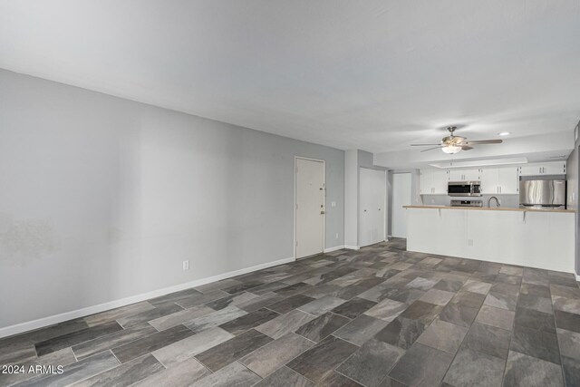 unfurnished living room featuring ceiling fan