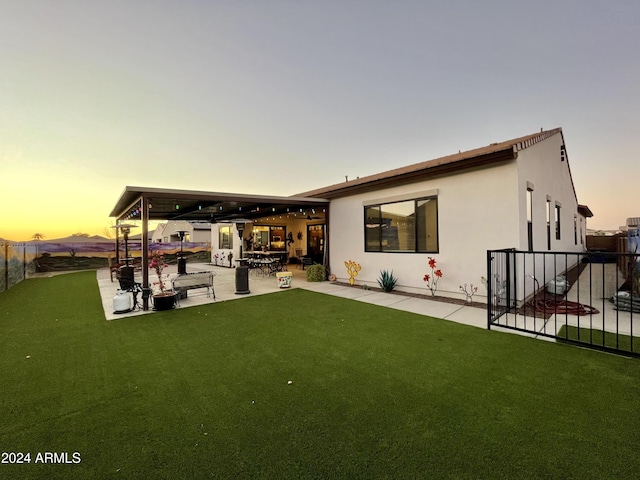 back of house with a yard, stucco siding, a patio, and fence