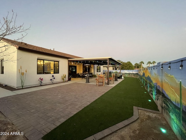 back of house with a patio area, a yard, a fenced backyard, and stucco siding