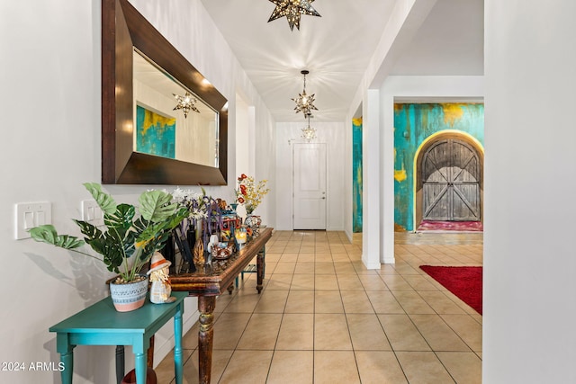 foyer with light tile patterned floors and a notable chandelier