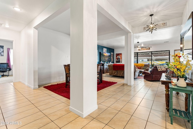 entryway featuring light tile patterned floors, baseboards, and an inviting chandelier