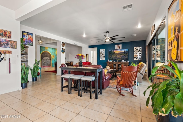 dining room featuring ceiling fan with notable chandelier, visible vents, and light tile patterned flooring