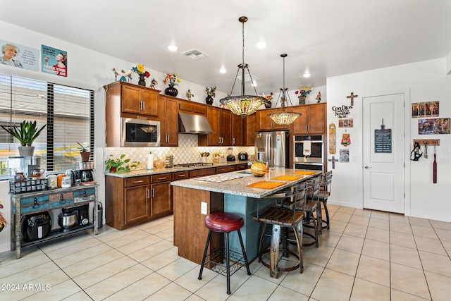 kitchen with appliances with stainless steel finishes, visible vents, under cabinet range hood, and light tile patterned floors