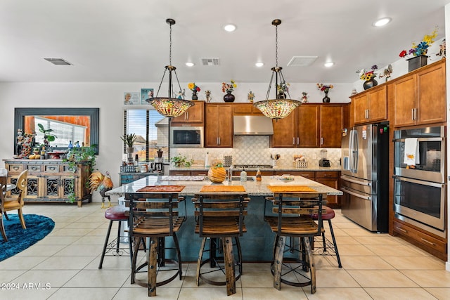 kitchen with light tile patterned floors, visible vents, backsplash, appliances with stainless steel finishes, and under cabinet range hood