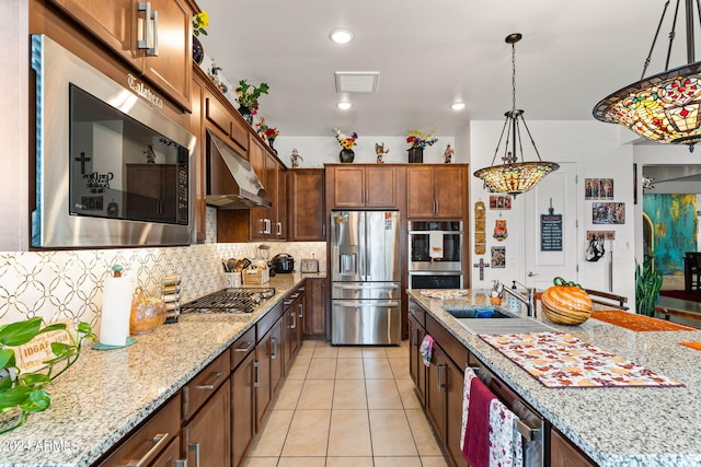 kitchen featuring decorative backsplash, appliances with stainless steel finishes, light tile patterned flooring, a sink, and under cabinet range hood