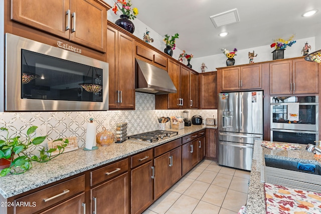 kitchen with light tile patterned floors, visible vents, decorative backsplash, appliances with stainless steel finishes, and under cabinet range hood