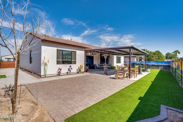 back of house featuring a patio, a lawn, a fenced backyard, and stucco siding