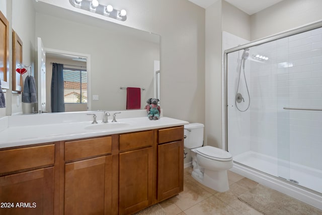 bathroom with tile patterned floors, toilet, vanity, and walk in shower