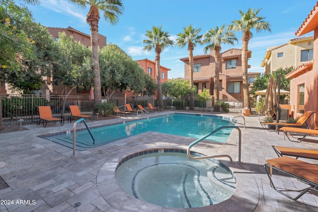 view of pool with a patio and a hot tub