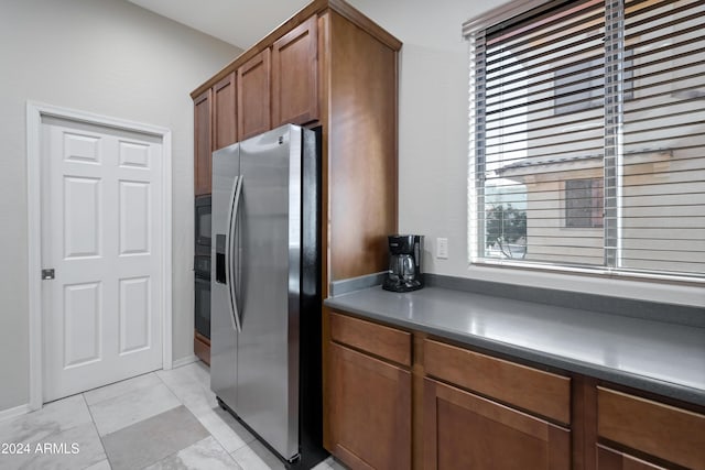 kitchen featuring black oven and stainless steel fridge