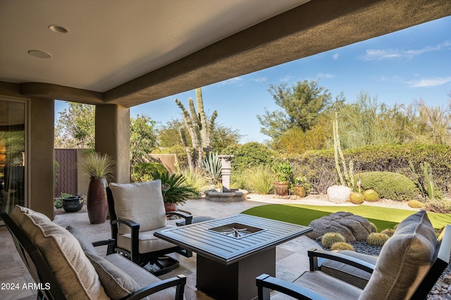 view of patio with an outdoor living space with a fire pit