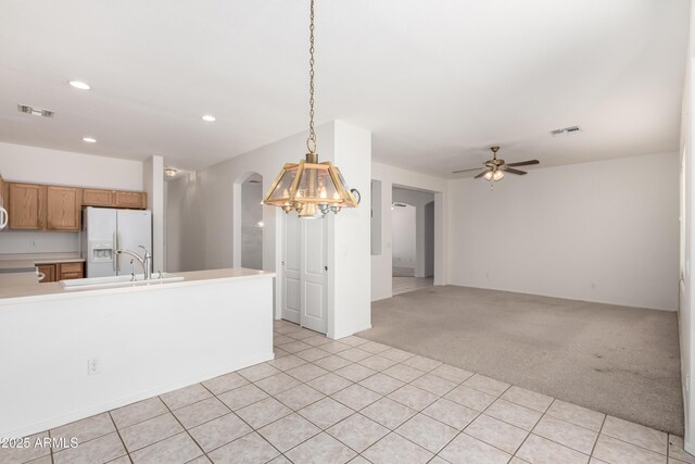 dining room with arched walkways, light tile patterned floors, a notable chandelier, light carpet, and visible vents