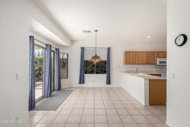 kitchen featuring light tile patterned floors, light countertops, visible vents, a sink, and white appliances